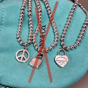 Set of 2 Tiffany & Co bead bracelets, peace sign, heart padlock